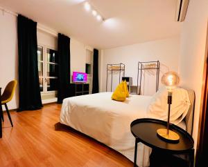 的里雅斯特Crops City Stay Apartment 14的一间卧室配有一张床、一张桌子和一台电视。