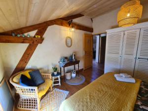 Saint-Sylvestre-sur-LotLe Coq en Repos的一间卧室配有一张床、一把椅子和一张桌子