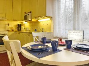 拉彭兰塔Finnish house near the forest的厨房配有黄色橱柜和白色的平板桌子