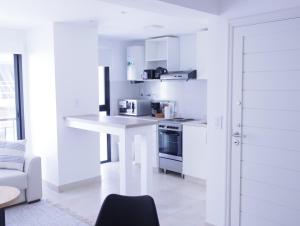 马德普拉塔5C Departamento de dos ambientes, por escalera.的厨房配有白色橱柜和白色台面