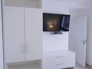 马德普拉塔5C Departamento de dos ambientes, por escalera.的白色客房,配有电视和白色橱柜