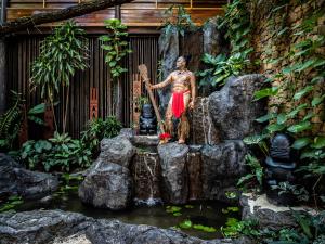 Motu TautauLe Taha'a by Pearl Resorts的站在池塘旁的女人雕像