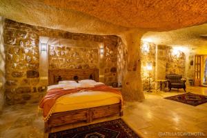 内夫谢希尔Atilla's Cave Hotel的卧室配有一张石墙床