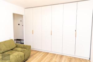 札勒乌Urban Nest的客厅配有白色橱柜和绿色沙发