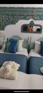 哈马马特克拉酒店的一间设有两张带镜子的床的房间,还有一位女士拍了照片