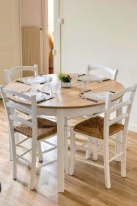 多勒Le Cocon d'Anna的白色的餐桌周围摆放着四把椅子
