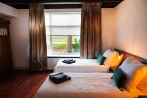OverschildPait's Laand Bed & Breakfast的酒店客房设有两张床和窗户。