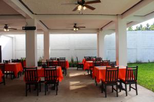 El MajahualMajahual Resort的一个带红色桌椅的庭院和吊扇