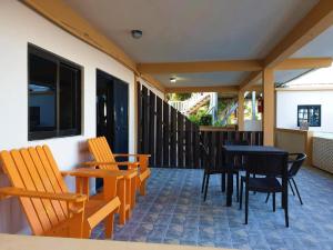 库尔克岛Beach Side Condos Caye Caulker by CCVH的庭院配有木椅和黑色的桌椅