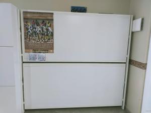罗塔SOLEA 17的配有海报的客房内的白色冰箱
