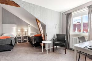 利雪平爱德华贝斯特韦斯特酒店的酒店客房带两张床和一张桌子以及椅子。
