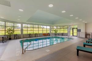 蒂明斯Best Western Premier Northwood Hotel的大楼内带桌椅的游泳池