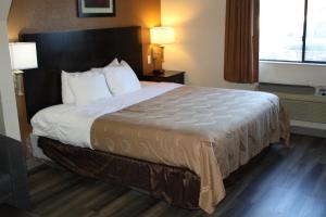 威奇托福尔斯Quality Inn & Suites Wichita Falls I-44的一张大床,位于酒店带两盏灯的房间