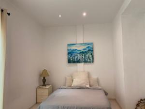 古晋古晋韦斯博里公寓的卧室配有一张床,墙上挂有绘画作品
