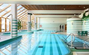 萨翁林纳赌场Spa酒店的拥有蓝色瓷砖的游泳池和天花板。