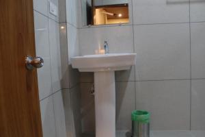 马迪凯里Vasathi的浴室设有白色水槽和镜子
