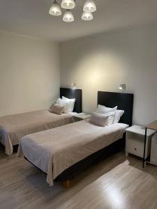 波西奥拉品萨图酒店的带2张桌子的房间的两张床