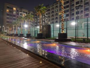 迪拜5*Amenities-2Br-15 min DxbApt,20min to Dubai Mall的棕榈树和建筑的游泳池