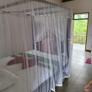 肯克拉哈巴拉杜瓦海滨别墅 的一间卧室配有一张带白色窗帘的床