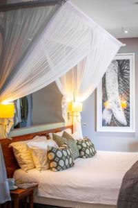 卡萨内Chobe Safari Lodges的卧室配有带枕头的天蓬床