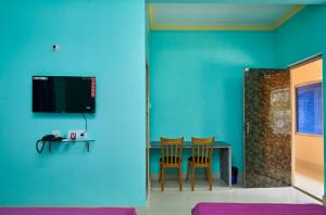 加尔各答deb Guest House And Banquet hall的配有桌椅和蓝色墙壁的客房