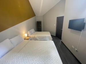 危地马拉Hotel Villas Santander的酒店客房设有两张床和一台平面电视。