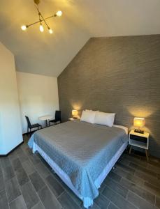 危地马拉Hotel Villas Santander的一间卧室配有一张带两张桌子和两盏灯的床。
