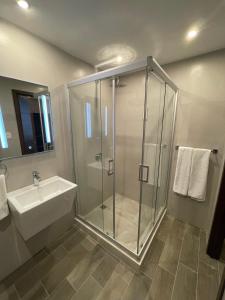 危地马拉Hotel Villas Santander的一间带玻璃淋浴和水槽的浴室