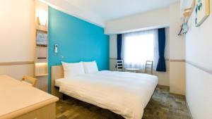松户市Toyoko Inn Matsudo eki Higashi guchi的酒店客房,设有床铺和蓝色的墙壁