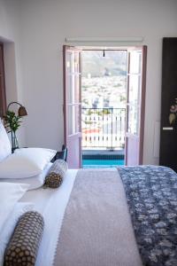 开普敦Dorp Hotel的一间卧室设有一张床,享有阳台的景色