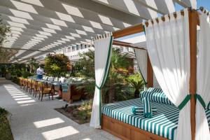 多哈The Ned Doha的一个带桌椅和白色天篷的庭院
