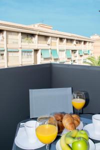 阿尔卡拉拉雷亚尔Deluxe Apartament Alcalá la Real的一张桌子,上面放着一盘食物和两杯橙汁
