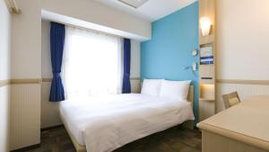 川口市Toyoko Inn Kawaguchi Ekimae的小房间设有床和窗户