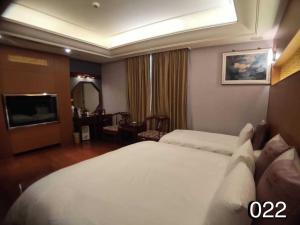 龙潭温馨汽车旅馆的酒店客房,配有床和电视