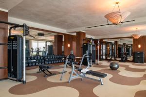 多哈The Ned Doha的一间健身房,配有数台跑步机和举重器材