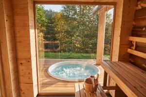 PerasdorfJakob Chalets的小木屋甲板上的按摩浴缸