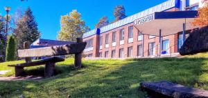 RøykenStorstua omsorgs- og konferansesenter的建筑物前草上的长凳