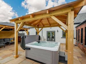 巴洛赫Westertonhill Holiday Lodges的天井上木凉棚下的热水浴池