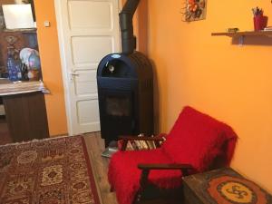 哈尔吉塔拜Orange House的一间带炉灶和红色椅子的客厅