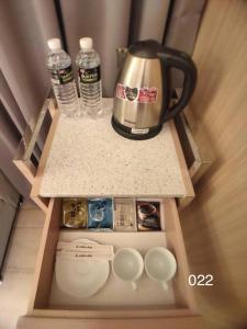 龙潭温馨汽车旅馆的咖啡壶和水瓶,放在柜台上