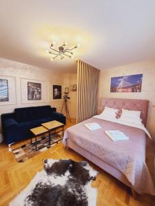帕莱Apartman Planinski Kutak的一间卧室配有一张床和一张蓝色的沙发