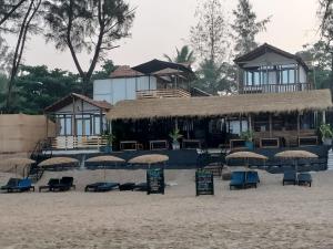 阿贡达Silent Waves的海滩上带椅子和遮阳伞的度假村