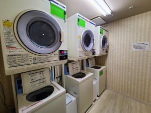 常滑市Spring Sunny Hotel Nagoya Tokoname ekimae的洗衣房配有3台洗衣机和干衣机