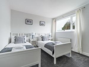 泰恩河畔纽卡斯尔Charming 3-Bed House in Newcastle upon Tyne的白色客房的两张床,设有窗户