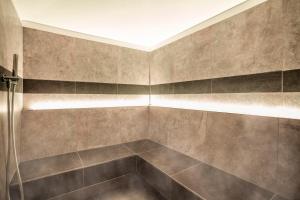 塞尔瓦迪加尔代纳山谷Luxury Chalet Plazola的一间带淋浴的浴室和瓷砖墙