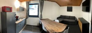 滨湖采尔Landhaus Marlies Apartments的一间带木桌和沙发的小厨房