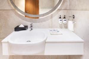艾哈迈达巴德Keys Select by Lemon Tree Hotels, Gandhi Ashram, Ahmedabad的浴室设有白色水槽和镜子