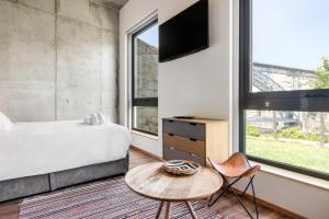 加亚新城Bridge It - Suites & Views的一间卧室配有一张床、一张桌子和一台电视。