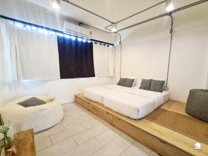 曼谷康帕尼恩旅舍的一间卧室设有两张床和窗户。