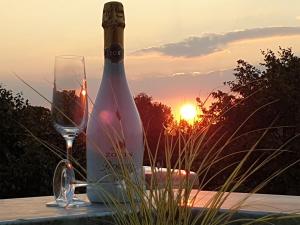 格赫伦-莱宾Luxus Spa Penthouse Sundowner的一瓶葡萄酒和一杯茶,在餐桌上欣赏日落美景
